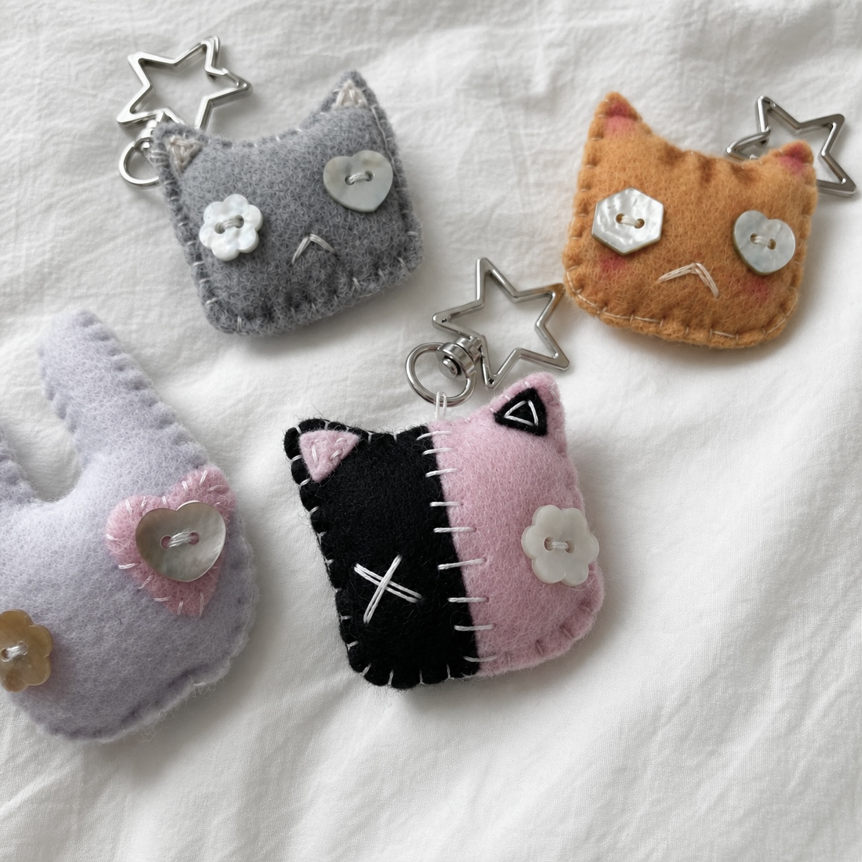 collection of mystery handmade felt keychains, including cats and a bunny
