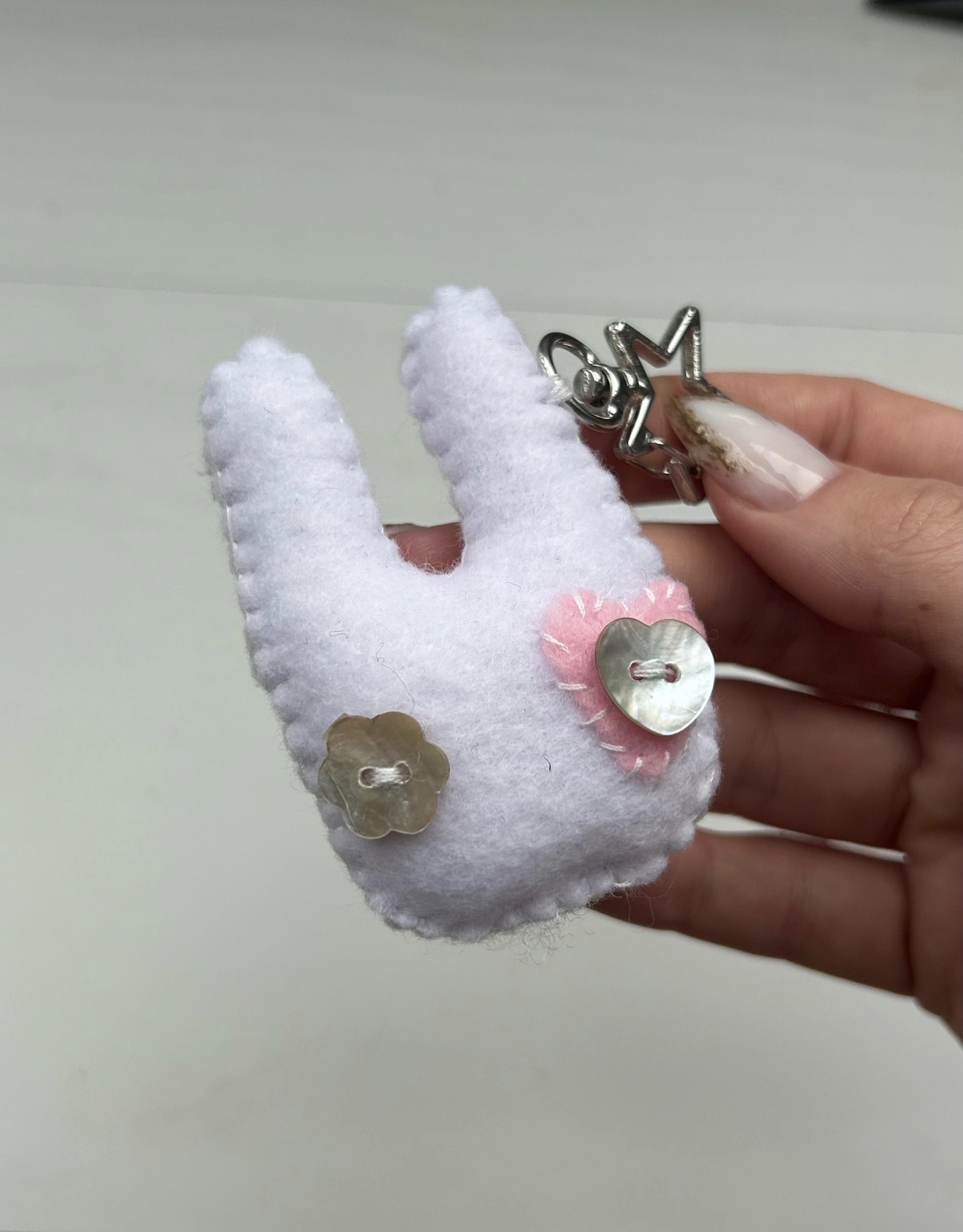 hand holding a white felt bunny keychain